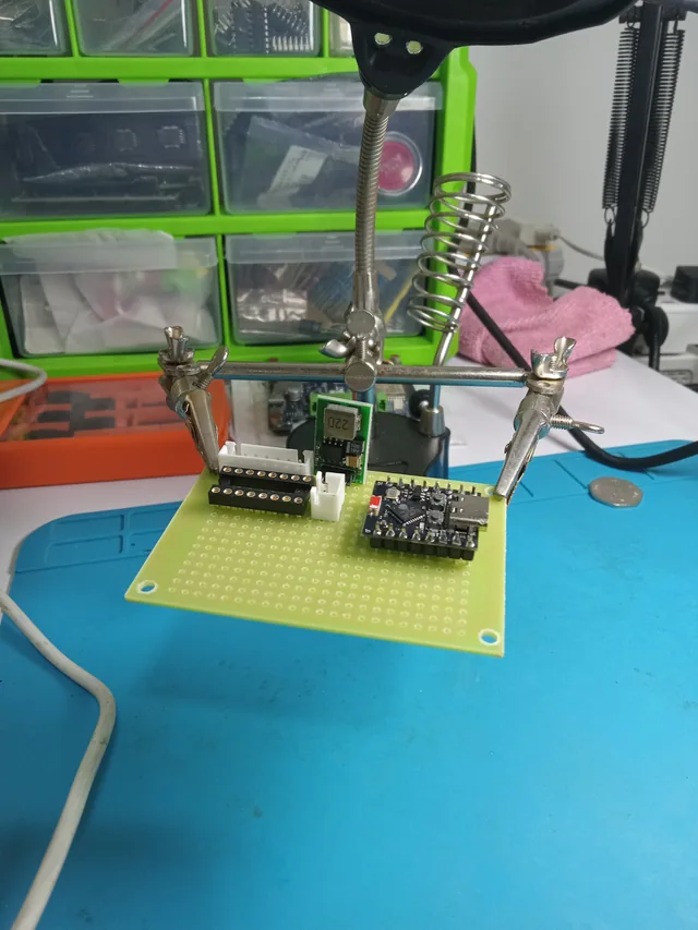 Microcontroller, power conversion, and connectors assembled on a prototype board at the electronics bench.